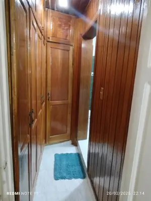 a hallway with a wooden door and a blue rug at Residencial Oasis in Juan López