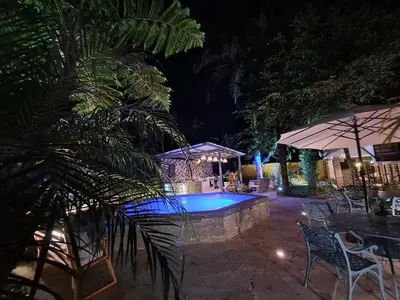 a pool at night with chairs and an umbrella at Villa la casita in Villa Altagracia