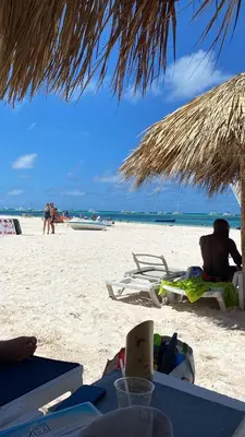 a person sitting in a chair on a beach at Fantástico Lugar en el Centro de los Corales RD in Punta Cana