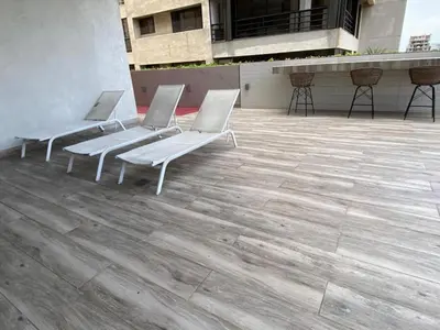 a row of white chairs sitting on a patio at Hermoso apartamento en el centro de la coudadt in Santo Domingo
