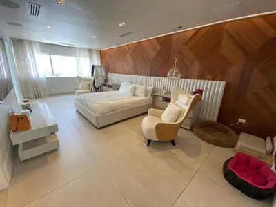 a bedroom with a bed and a couch and a chair at Hermoso apartamento en el centro de la coudadt in Santo Domingo