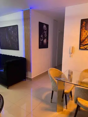 a living room with a glass table and chairs at Apartamento Bello y Amueblado in Jacagua