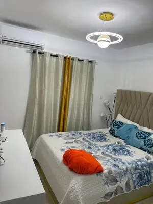 a bedroom with a bed with an orange pillow on it at Apartamento Bello y Amueblado in Jacagua