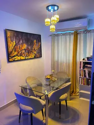 a dining room with a glass table and chairs at Apartamento Bello y Amueblado in Jacagua