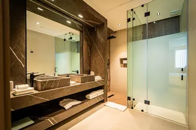 a bathroom with two sinks and a large mirror at Nohian Collection Hotels in Santiago de los Caballeros