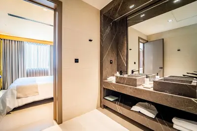 a bathroom with two sinks and a large mirror at Nohian Collection Hotels in Santiago de los Caballeros
