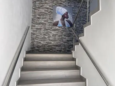 a stairway with a painting of a woman on a brick wall at Level Suites 3 Premium Suite in Sosúa