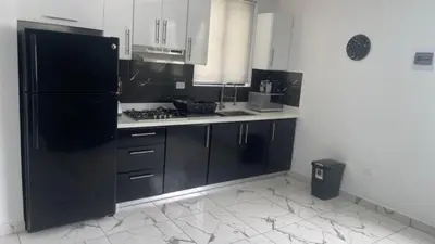 a kitchen with a black refrigerator and a stove at Level Suites 3 Premium Suite in Sosúa