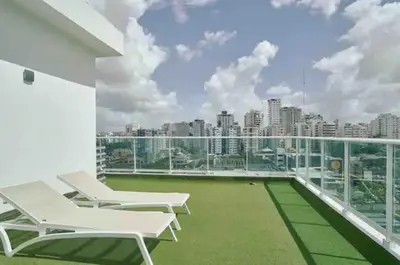 a balcony with white chairs and a view of the city at Natural Boho Places QDA-III in Santo Domingo
