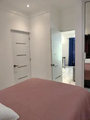 a bedroom with white walls and a bed and a bathroom at Vacacional Laas Pascualas in Sánchez