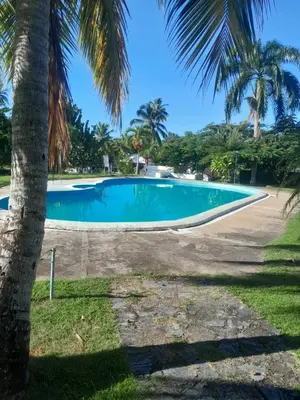 a swimming pool with palm trees in the foreground at Vacacional Laas Pascualas in Sánchez