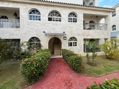 a large stone building with a red brick driveway at Cozy Condo - 4 min to the Beach in Punta Cana