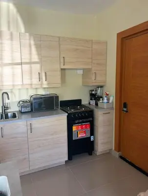 a kitchen with wooden cabinets and a black stove top oven at Villa Atlantica Punta Cana in Punta Cana