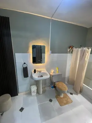 a bathroom with a sink and a toilet and a tv at Habitación a 15min del aeropuerto in La Caleta