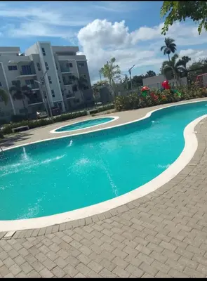 a swimming pool with blue water in front of some buildings at Lux 3BR Oasis With Gazebo & Pool in Pontezuela Arriba