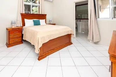 a bedroom with a bed and a white tiled floor at Villa Olga in Sosúa