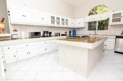 a white kitchen with white cabinets and a counter top at Villa Olga in Sosúa