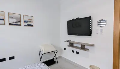 a living room with a tv on a white wall at Mountain View Penthouse Condo in Muñoz