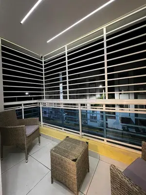 a room with a balcony with chairs and a large window at Apartamento O3 Palma Real in Santiago de los Caballeros