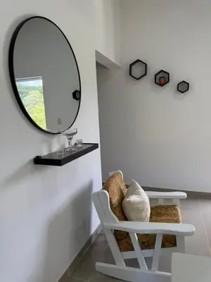 a mirror and a white chair in a room at Apartamento Media Luna in Cabrera