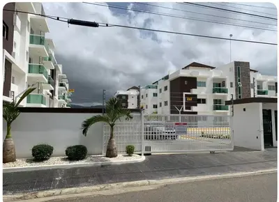 a white fence in front of some buildings at Exclusive Luxury Apartment with Pool in Santiago de los Caballeros