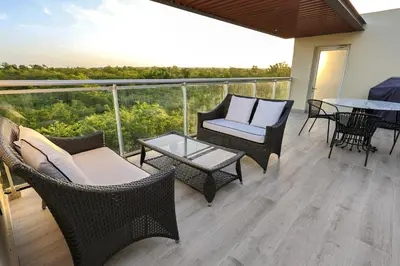 a balcony with wicker chairs and tables and a view at 404 y 504 Luxurious PH with Jacuzzi near the Beach in La Laguna