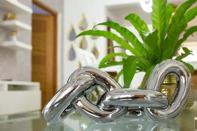 a chrome heart vase with a plant on a table at 0052-Brand new oceanfront condo in Cabarete in Eslabón