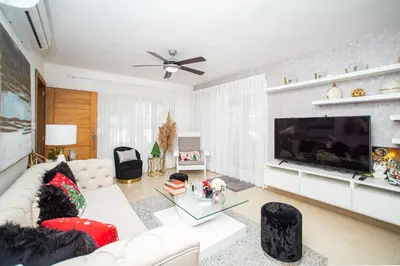 a living room with a white couch and a large television at 0052-Brand new oceanfront condo in Cabarete in Eslabón