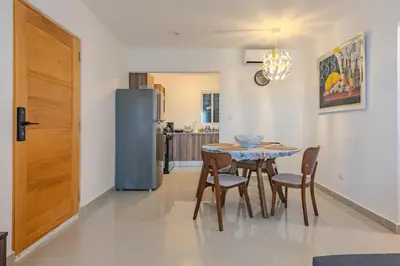 a kitchen with a table and chairs and a refrigerator at Oasis cerca del mar #2 in Monte Adentro