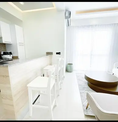 a white kitchen with white chairs and a table at Apartamento boca chica in Andrés