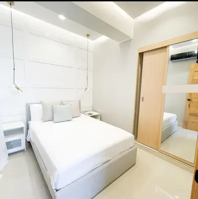 a white bedroom with a bed and a window at Apartamento boca chica in Andrés