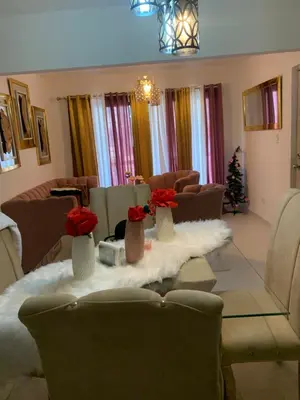 a living room with a table with red roses in vases at habitat 1 t4 101 ciudad juan Bosch in San Isidro