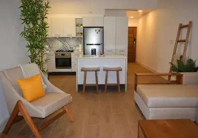 a living room with a couch and a kitchen at Perla Marina Beach Condo- Walk to Yoga, Spa & Food in Sosúa