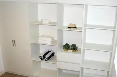 a white book shelf in a room at Perla Marina Beach Condo- Walk to Yoga, Spa & Food in Sosúa
