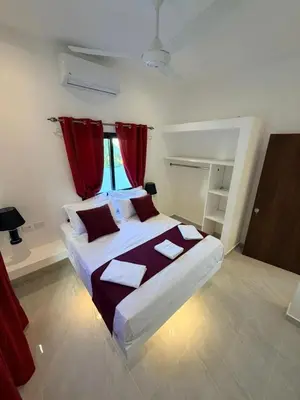 a bedroom with a large bed with red curtains at Taina village in Las Terrenas