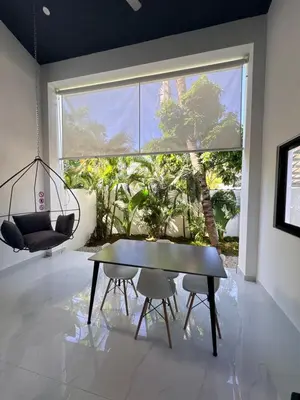 a room with a table and chairs and a large window at Taina village in Las Terrenas