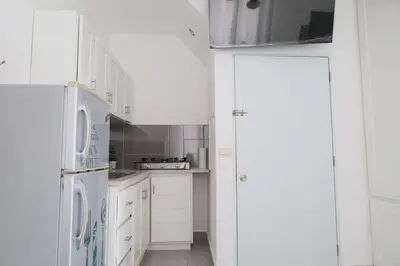 a white kitchen with white cabinets and appliances at Ilaria Bayahibe By Mireya in Bayahibe