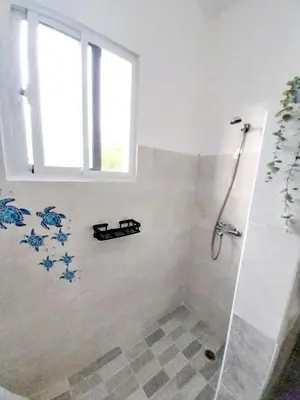 a bathroom with a shower with blue flowers on the wall at Ilaria Bayahibe By Mireya in Bayahibe