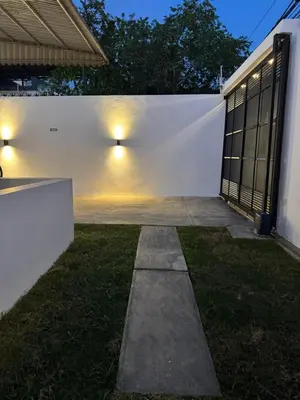 a white fence with lights on the side of a house at Heyday Studio With Full Kitchenette in Santiago de los Caballeros