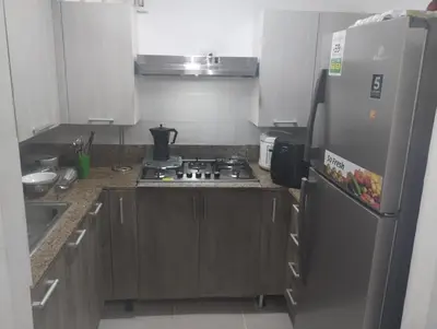 a kitchen with a stove and a refrigerator at Cómodo Apartamento en Santiago in Santiago de los Caballeros