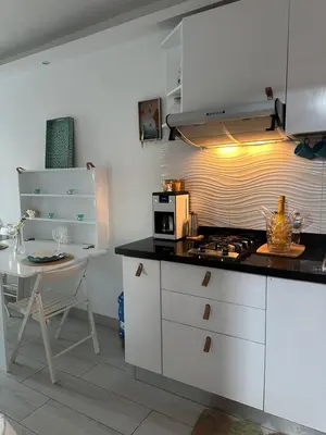 a kitchen with white cabinets and a table and a stove at Apartamento lll Vista al Mar Albatros by ju Juan Dolio in Villas del Mar