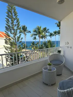 a balcony with a view of the ocean and palm trees at Apartamento lll Vista al Mar Albatros by ju Juan Dolio in Villas del Mar
