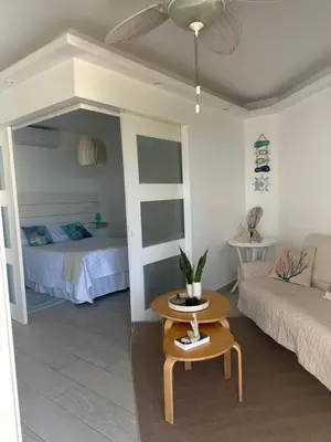 a living room with a bed and a table at Apartamento lll Vista al Mar Albatros by ju Juan Dolio in Villas del Mar