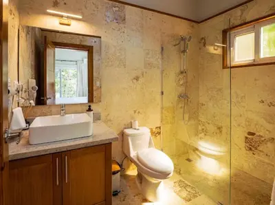 a bathroom with a toilet and a sink and a shower at Modern 6 Br Villa With Hot Tub in Sosúa
