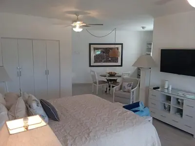 a bedroom with a bed and a table and a television at Cadaques Bayahibe Beach Front in Bayahibe