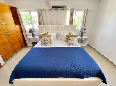 a bedroom with a large bed with a blue blanket at pavilus in Punta Cana