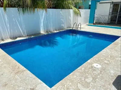 a swimming pool with blue water in front of a fence at pavilus in Punta Cana