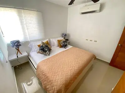 a small bedroom with a bed with pillows on it at pavilus in Punta Cana