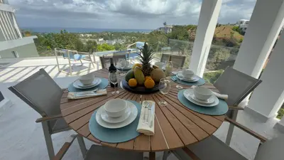 a wooden table with a bowl of fruit on a balcony at Oceanview Villa With King Beds in Las Terrenas