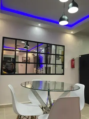 a dining room with a glass table and white chairs at Apartmento Xbox WFI TV65 PC Love Relax Work in La Cana